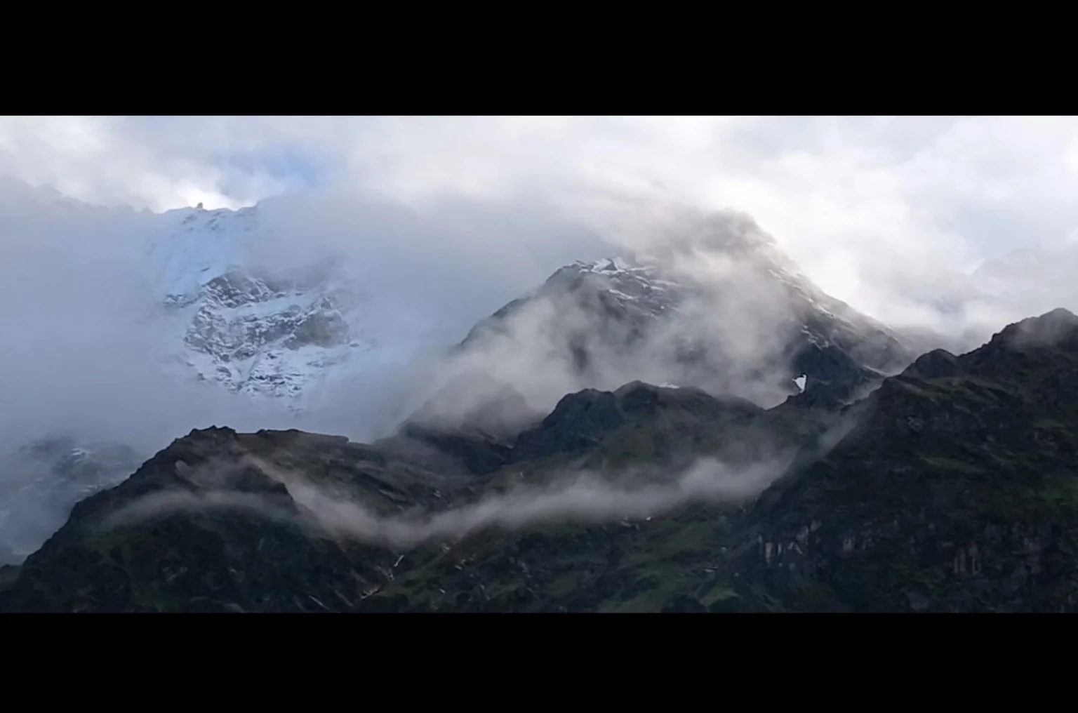 Mountain, snow, cloud, vegetation and light sharing one changing landscape